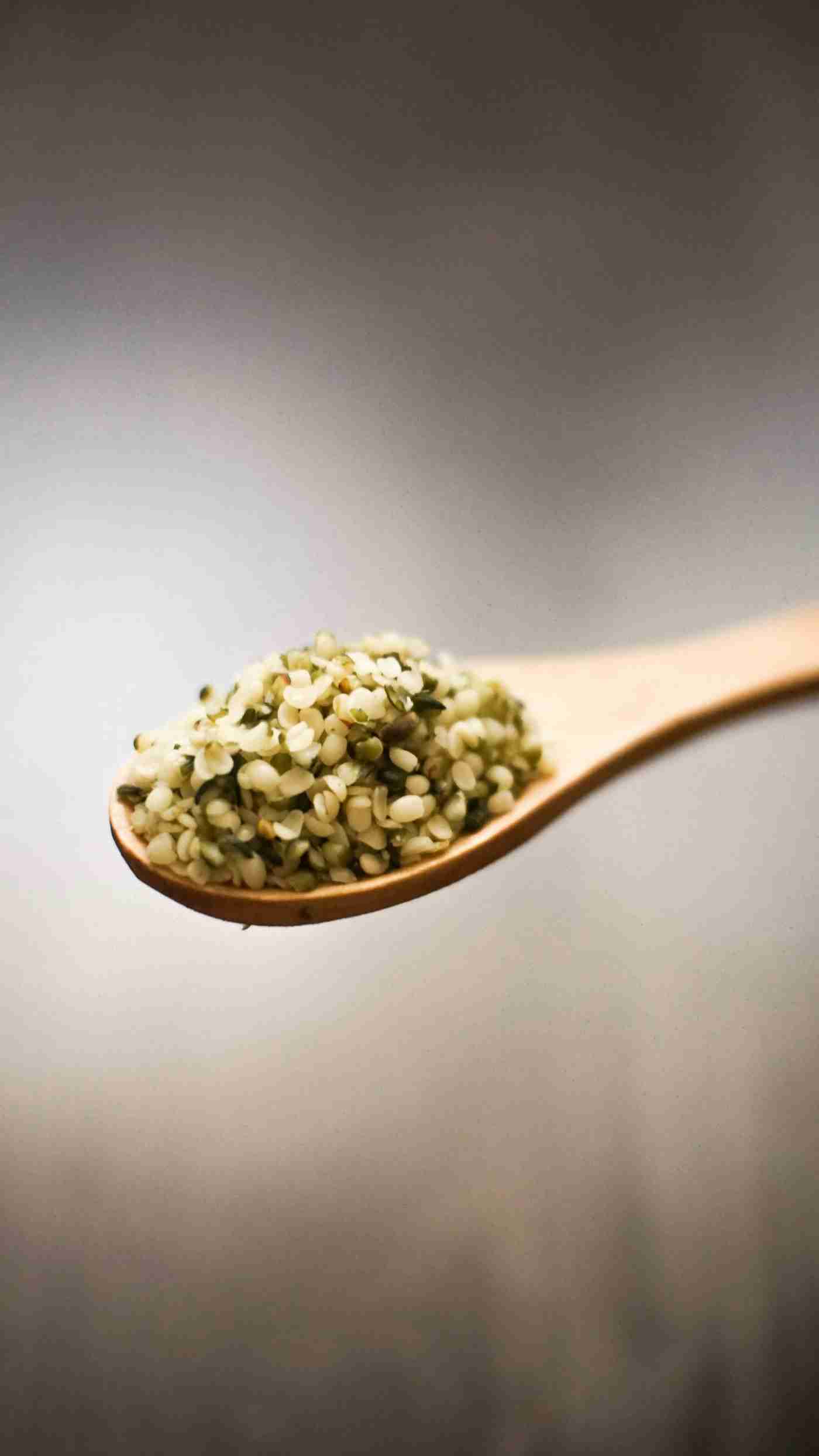 Hulled hemp hearts in a wooden spoon, distinct from planting seed